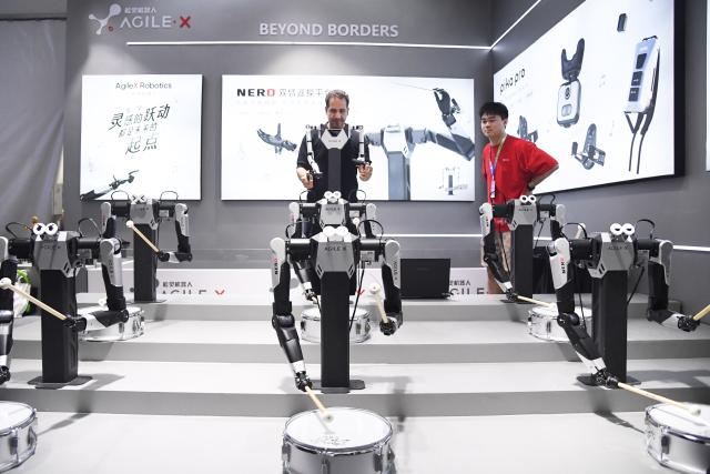 (260819) -- BEIJING, Aug. 19, 2026 (Xinhua) -- A visitor tries remotely controlled robotic arms during the 2026 World Robot Conference in Beijing, capital of China, Aug. 19, 2026. Themed "Human-Robot Symbiosis, Production-Demand Convergence," the 2026 edition of the conference kicked off here on Wednesday. (Xinhua/Ren Chao)