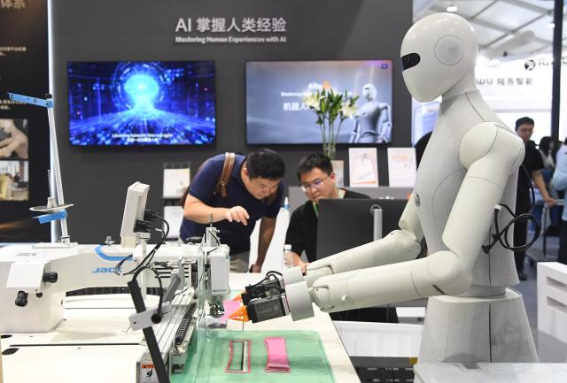 (260819) -- BEIJING, Aug. 19, 2026 (Xinhua) -- A robot demonstrates sewing skills during the 2026 World Robot Conference in Beijing, capital of China, Aug. 19, 2026. Themed "Human-Robot Symbiosis, Production-Demand Convergence," the 2026 edition of the conference kicked off here on Wednesday. (Xinhua/Ren Chao)