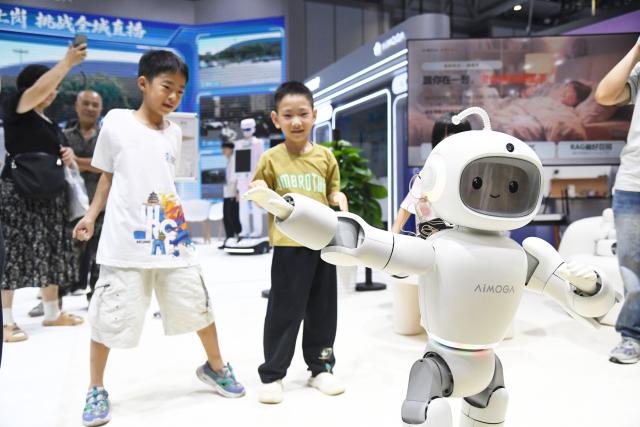 (260819) -- BEIJING, Aug. 19, 2026 (Xinhua) -- A cartoonized robot interacts with children during the 2026 World Robot Conference in Beijing, capital of China, Aug. 19, 2026. Themed "Human-Robot Symbiosis, Production-Demand Convergence," the 2026 edition of the conference kicked off here on Wednesday. (Xinhua/Ren Chao)