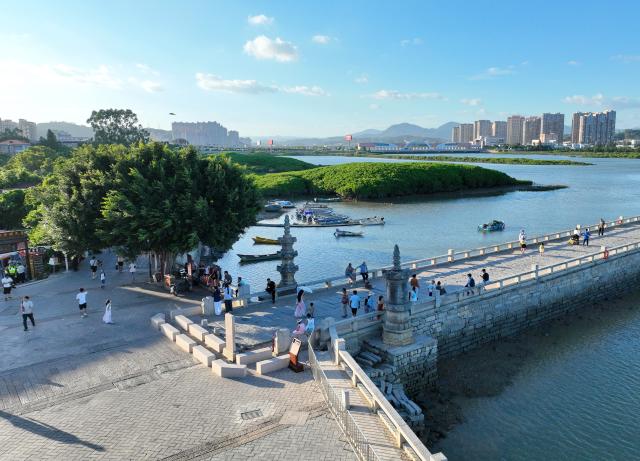(260819) -- QUANZHOU, Aug. 19, 2026 (Xinhua) -- An aerial drone photo taken on Aug. 18, 2026 shows tourists visiting Luoyang Bridge in Quanzhou, southeast China's Fujian Province. Luoyang Bridge, also known as Wan'an Bridge, is a component of the UNESCO World Heritage site "Quanzhou: Emporium of the World in Song-Yuan China." 
  In recent years, Quanzhou has woven cultural heritage into daily life by introducing intangible cultural heritage programs and cultural and creative businesses, attracting more tourists to the area. (Xinhua/Lin Shanchuan)