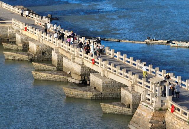 (260819) -- QUANZHOU, Aug. 19, 2026 (Xinhua) -- An aerial drone photo taken on Aug. 18, 2026 shows tourists visiting Luoyang Bridge in Quanzhou, southeast China's Fujian Province. Luoyang Bridge, also known as Wan'an Bridge, is a component of the UNESCO World Heritage site "Quanzhou: Emporium of the World in Song-Yuan China." 
  In recent years, Quanzhou has woven cultural heritage into daily life by introducing intangible cultural heritage programs and cultural and creative businesses, attracting more tourists to the area. (Xinhua/Lin Shanchuan)