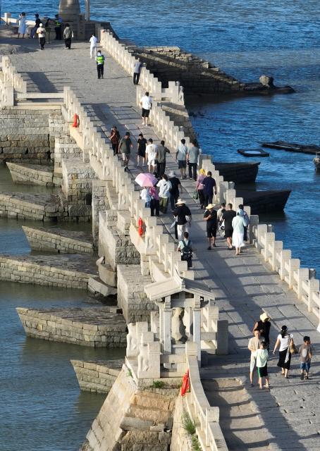 (260819) -- QUANZHOU, Aug. 19, 2026 (Xinhua) -- An aerial drone photo taken on Aug. 18, 2026 shows tourists visiting Luoyang Bridge in Quanzhou, southeast China's Fujian Province. Luoyang Bridge, also known as Wan'an Bridge, is a component of the UNESCO World Heritage site "Quanzhou: Emporium of the World in Song-Yuan China." 
  In recent years, Quanzhou has woven cultural heritage into daily life by introducing intangible cultural heritage programs and cultural and creative businesses, attracting more tourists to the area. (Xinhua/Lin Shanchuan)