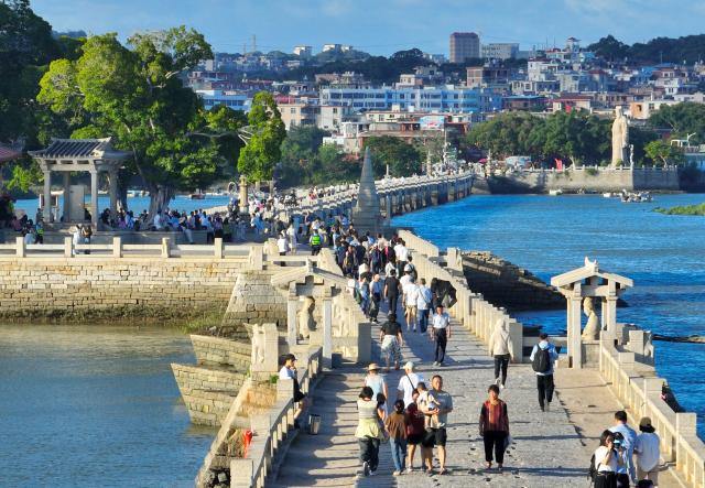 (260819) -- QUANZHOU, Aug. 19, 2026 (Xinhua) -- An aerial drone photo taken on Aug. 18, 2026 shows tourists visiting Luoyang Bridge in Quanzhou, southeast China's Fujian Province. Luoyang Bridge, also known as Wan'an Bridge, is a component of the UNESCO World Heritage site "Quanzhou: Emporium of the World in Song-Yuan China." 
  In recent years, Quanzhou has woven cultural heritage into daily life by introducing intangible cultural heritage programs and cultural and creative businesses, attracting more tourists to the area. (Xinhua/Lin Shanchuan)