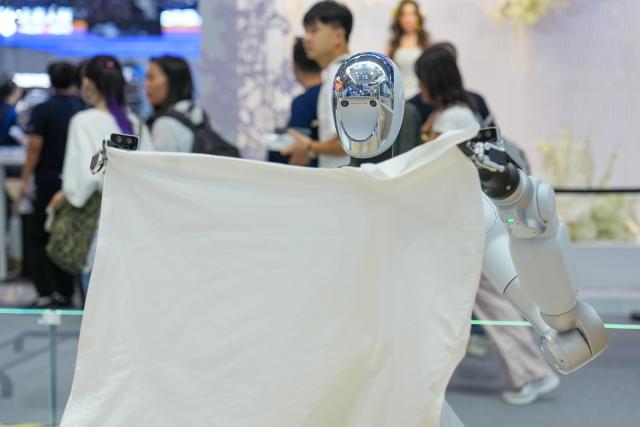 (260819) -- BEIJING, Aug. 19, 2026 (Xinhua) -- A robot demonstrates folding clothes during the 2026 World Robot Conference in Beijing, capital of China, Aug. 19, 2026. Themed "Human-Robot Symbiosis, Production-Demand Convergence," the 2026 edition of the conference kicked off here on Wednesday. (Xinhua/Ju Huanzong)