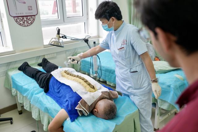 (260819) -- YINCHUAN, Aug. 19, 2026 (Xinhua) -- Mohammad Abdi learns about a traditional Chinese medical treatment therapy at Ningxia Chinese Medicine Research Center in Yinchuan, northwest China's Ningxia Hui Autonomous Region, on Aug. 15, 2026. Mohammad Abdi, a 26-year-old Iranian student, came to China in 2023 to study clinical medicine at Ningxia Medical University.
   He was introduced to traditional Chinese medicine (TCM) at an early age. After seeing his uncle receive cupping therapy in Iran, he became curious about this traditional medical practice. Later, as a medical student in China, he had the opportunity to take professional TCM courses. On weekends, Abdi visits Ningxia Chinese Medicine Research Center to experience various TCM therapies.
   "I was a gym rat, so I initially thought TCM practices were too simple to be effective," he said. However, as he learned more about TCM, he was impressed by its depth and effectiveness. He recommended Baduanjin, a traditional Chinese breathing and stretching exercise, to his fellow international students, while he especially enjoys tuina massage combined with cupping therapy, which helps relieve the stress of his studies and clinical internship.
   For Abdi, TCM is more than a way to treat diseases; it is also a health philosophy that can be integrated into daily life. He believes ordinary people can benefit from TCM-based wellness practices, while professional doctors can use TCM techniques to treat patients.
   TCM is now expanding its global presence and joining the worldwide conversation on health and lifestyle. Inspired by growing interest in Chinese lifestyles overseas, Abdi hopes to continue exploring TCM and become a skilled doctor, helping more people in his hometown benefit from traditional Chinese medicine. (Xinhua/Yang Zhisen)