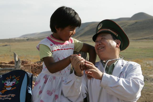 (260819) -- URUMQI, Aug. 19, 2026 (Xinhua) -- Zhuang Shihua talks with a little girl who was once deprived of education and returned to school with his help in northwest China's Xinjiang Uygur Autonomous Region, Aug. 26, 2006.
  Zhuang Shihua, a veteran hepatobiliary surgeon and former president of the hospital affiliated to the Xinjiang Armed Police Corps, has been in the country's far west for over five decades.
  His team has successfully completed more than 140,000 minimally invasive hepatobiliary surgeries, and made seven breakthroughs that filled the domestic gap in the field. Apart from clinical practice, Zhuang has cultivated a large number of key personnel, and supported grassroots medical workers who have stood firm on the front lines of public health.
  Zhuang's medical expertise brought him many opportunities to make a fortune, but he turned down the offers and stayed in Xinjiang.
  Zhuang often visited patients in the pastoral areas of Tianshan Mountains. He also provided financial assistance to over 70 underprivileged students and helped more than 690 households with patients out of poverty. (Photo by Liu Haishan/Xinhua)