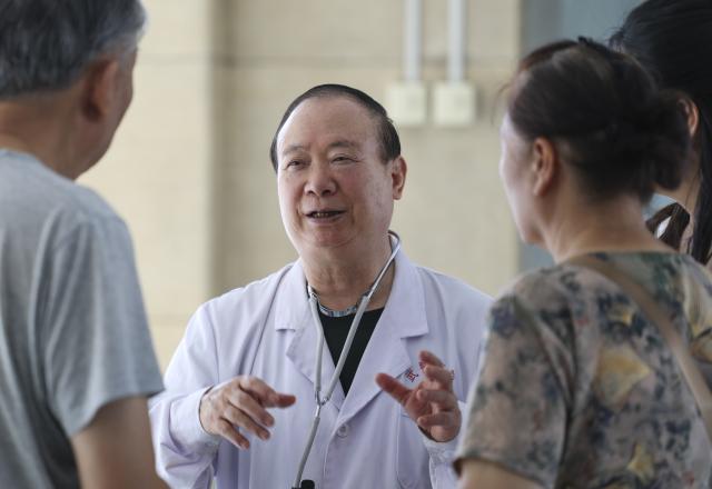 (260819) -- URUMQI, Aug. 19, 2026 (Xinhua) -- Zhuang Shihua talks with a patient and his family at the hospital affiliated to the Xinjiang Armed Police Corps in Urumqi, northwest China's Xinjiang Uygur Autonomous Region, Aug. 18, 2026.
  Zhuang Shihua, a veteran hepatobiliary surgeon and former president of the hospital affiliated to the Xinjiang Armed Police Corps, has been in the country's far west for over five decades.
  His team has successfully completed more than 140,000 minimally invasive hepatobiliary surgeries, and made seven breakthroughs that filled the domestic gap in the field. Apart from clinical practice, Zhuang has cultivated a large number of key personnel, and supported grassroots medical workers who have stood firm on the front lines of public health.
  Zhuang's medical expertise brought him many opportunities to make a fortune, but he turned down the offers and stayed in Xinjiang.
  Zhuang often visited patients in the pastoral areas of Tianshan Mountains. He also provided financial assistance to over 70 underprivileged students and helped more than 690 households with patients out of poverty. (Xinhua/Wang Fei)