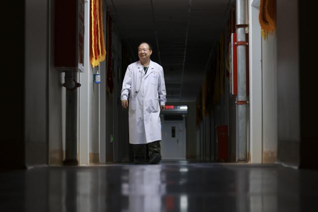 (260819) -- URUMQI, Aug. 19, 2026 (Xinhua) -- Zhuang Shihua is on his ward rounds at night at the hospital affiliated to the Xinjiang Armed Police Corps in Urumqi, northwest China's Xinjiang Uygur Autonomous Region, July 27, 2026.
  Zhuang Shihua, a veteran hepatobiliary surgeon and former president of the hospital affiliated to the Xinjiang Armed Police Corps, has been in the country's far west for over five decades.
  His team has successfully completed more than 140,000 minimally invasive hepatobiliary surgeries, and made seven breakthroughs that filled the domestic gap in the field. Apart from clinical practice, Zhuang has cultivated a large number of key personnel, and supported grassroots medical workers who have stood firm on the front lines of public health.
  Zhuang's medical expertise brought him many opportunities to make a fortune, but he turned down the offers and stayed in Xinjiang.
  Zhuang often visited patients in the pastoral areas of Tianshan Mountains. He also provided financial assistance to over 70 underprivileged students and helped more than 690 households with patients out of poverty. (Xinhua/Wang Fei)