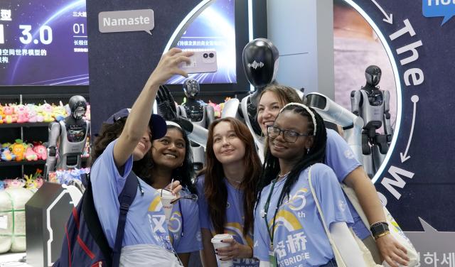 (260820) -- BEIJING, Aug. 20, 2026 (Xinhua) -- Visitors take selfies with a robot during the 2026 World Robot Conference in Beijing, capital of China, Aug. 19, 2026. Themed "Human-Robot Symbiosis, Production-Demand Convergence," the 2026 edition of the conference kicked off here on Wednesday. (Photo by Bi Shanghong/Xinhua)