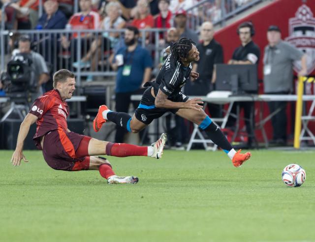 (260820) -- TORONTO, Aug. 20, 2026 (Xinhua) -- Walker Zimmerman (L) of Toronto FC vies with Idan Toklomati of Charlotte FC during the 2026 Major League Soccer (MLS) regular season match between Toronto FC and Charlotte FC at BMO Field in Toronto, Canada, on Aug. 19, 2026. (Photo by Zou Zheng/Xinhua)
