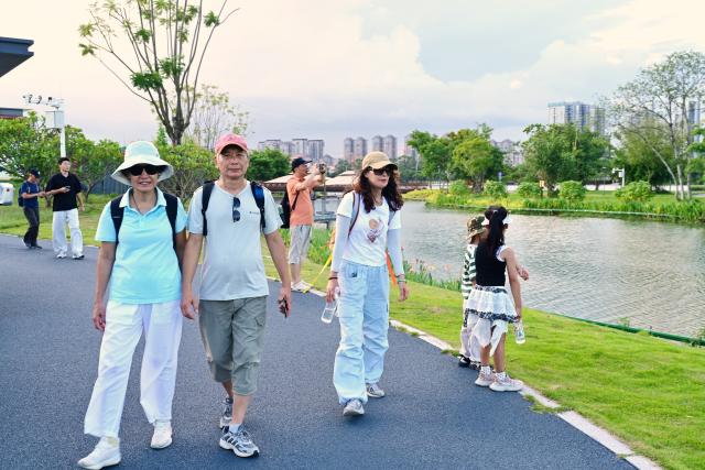 (260820) -- ZHANGZHOU, Aug. 20, 2026 (Xinhua) -- Tourists visit Longjiang Suiyue park in Zhangzhou, southeast China's Fujian Province, Aug. 19, 2026. Longjiang Suiyue park, a cultural and tourism complex, was transformed from an area with dilapidated buildings, widespread garbage, and wasted water. The renovated park officially opened on Dec. 31, 2024, and has attracted over 18 million visitors as of this June. (Xinhua/Lin Shanchuan)