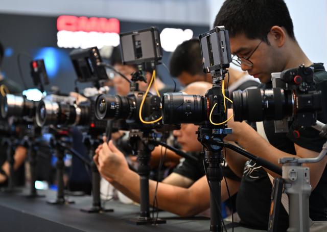 (260820) -- BEIJING, Aug. 20, 2026 (Xinhua) -- Visitors try products during the 33rd Beijing International Radio, TV & Film Exhibition (BIRTV 2026) in Beijing, capital of China, Aug. 20, 2026. The ongoing 33rd Beijing International Radio, TV & Film Exhibition is held here from Aug. 19 to Aug. 22. (Xinhua/Zheng Huansong)