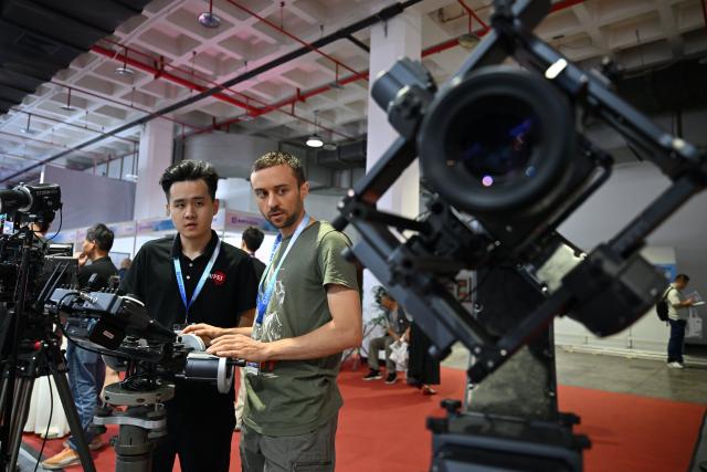 (260820) -- BEIJING, Aug. 20, 2026 (Xinhua) -- Visitors experience a remote control equipment for stabilizers during the 33rd Beijing International Radio, TV & Film Exhibition (BIRTV 2026) in Beijing, capital of China, Aug. 20, 2026. The ongoing 33rd Beijing International Radio, TV & Film Exhibition is held here from Aug. 19 to Aug. 22. (Xinhua/Zheng Huansong)
