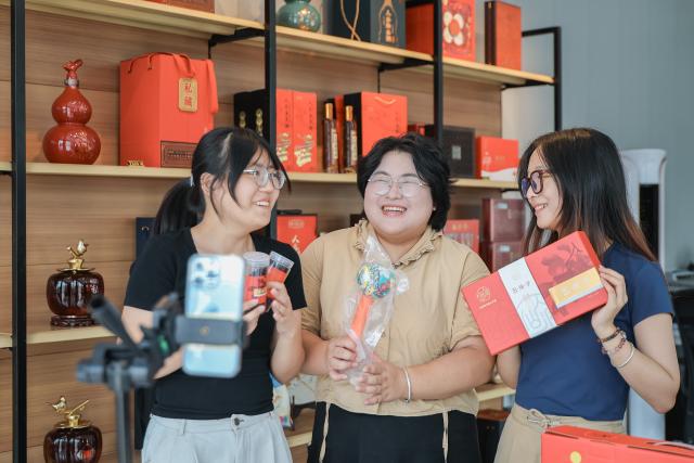 (260820) -- BAISHAN, Aug. 20, 2026 (Xinhua) -- College student volunteers promote local specialties through livestreaming at Xiaochangchuan Village of Sandaogou Town, in Baishan City, northeast China's Jilin Province, Aug. 19, 2026. Thanks to national highway G331 which opened for public transportation in September 2025, Sandaogou Town, once a remote mountainous town backward in development, has seized new opportunities to foster local businesses in cultivation, tourism and other services. (Xinhua/Xu Chang)