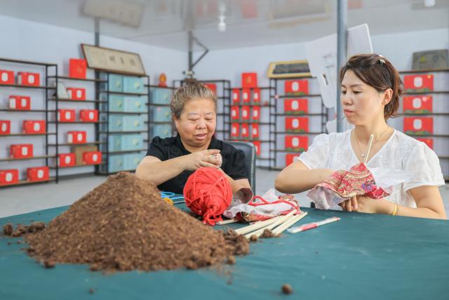 (260820) -- BAISHAN, Aug. 20, 2026 (Xinhua) -- People prepare health products made with fruits of Chinese magnoliavine at a company in Sandaogou Town of Baishan City, northeast China's Jilin Province, Aug. 19, 2026. Thanks to national highway G331 which opened for public transportation in September 2025, Sandaogou Town, once a remote mountainous town backward in development, has seized new opportunities to foster local businesses in cultivation, tourism and other services. (Xinhua/Xu Chang)