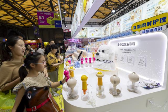 (260820) -- SHANGHAI, Aug. 20, 2026 (Xinhua) -- Visitors look at a pet bathing scenario at the 28th Pet Fair Asia in east China's Shanghai, Aug. 20, 2026. Held from Aug. 19 to Aug. 23, the pet fair has attracted over 2,600 exhibitors. (Xinhua/Wang Xiang)