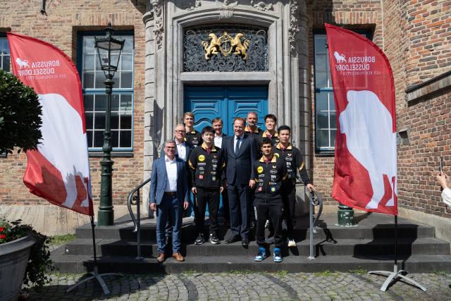 (260820) -- DUSSELDORF, Aug. 20, 2026 (Xinhua) -- Stephan Keller (5th R), mayor of Dusseldorf, and Chinese table tennis star Fan Zhendong (4th L) and members of Borussia Dusseldorf pose for group photos after a welcoming ceremony in Dusseldorf, Germany, Aug. 20, 2026. Fan Zhendong was officially unveiled by his new club Borussia Dusseldorf at a press conference here on Thursday, as the Olympic champion prepares for his second season in the German Table Tennis Bundesliga and another campaign in European competition. (Xinhua/Zhang Haofu)