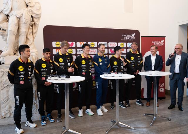 (260820) -- DUSSELDORF, Aug. 20, 2026 (Xinhua) -- Table tennis players American Kanak Jha (2nd L), Sweden's Anton Kallberg (3rd L), Germany's Qiu Dang (4th L), China's Li Yongyin (1st L) and Fan Zhendong (4th R), German table tennis star Timo Boll (5th L) and head coach Danny Heister (3rd R) attend a press conference after a welcoming ceremony in Dusseldorf, Germany, Aug. 20, 2026. Chinese table tennis star Fan Zhendong was officially unveiled by his new club Borussia Dusseldorf at a press conference here on Thursday, as the Olympic champion prepares for his second season in the German Table Tennis Bundesliga and another campaign in European competition. (Xinhua/Zhang Haofu)