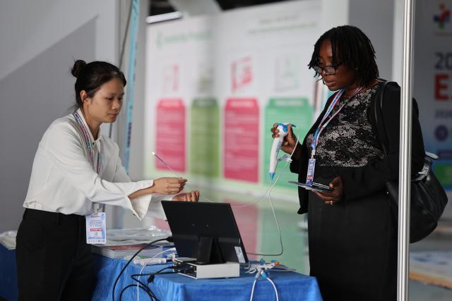 (260820) -- ACCRA, Aug. 20, 2026 (Xinhua) -- An exhibitor introduces medical equipment to a visitor at the third China-West Africa Medical Expo and AI Diagnosis Summit in Accra, Ghana, Aug. 19, 2026. TO GO WITH "Roundup: Ghana proposes deeper China-West Africa cooperation for improved regional health outcomes" (Photo by Seth/Xinhua)