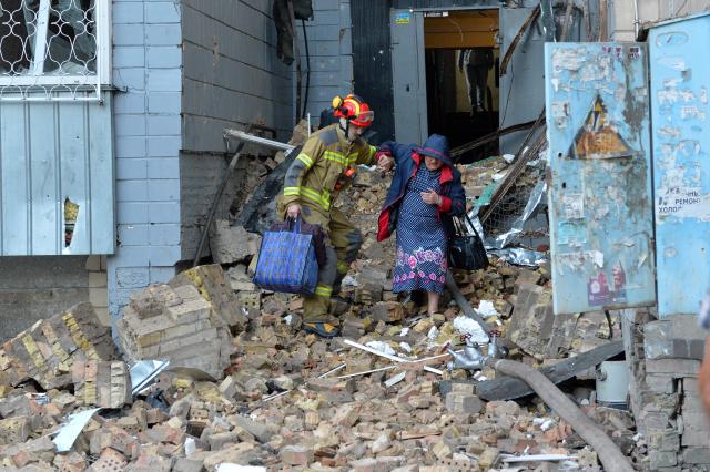 (260820) -- KIEV, Aug. 20, 2026 (Xinhua) -- A rescuer helps a woman evacuate from a building damaged in a Russian overnight missile and drone attack in Kiev, Ukraine, Aug. 20, 2026. A Russian overnight missile and drone attack hits Kyiv, Ukraine, on August 20, 2026. (Photo by Peter Druk/Xinhua)