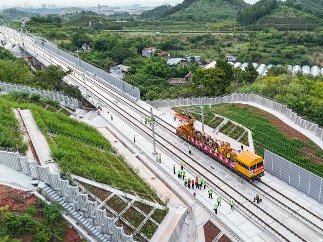 (260821) --CHENGDU, Aug. 21, 2026 (Xinhua) -- An aerial photo shows constructors installing overhead contact wires along the Jianzhou-Lezhi section of the Chengdu-Chongqing Central Line High-Speed Railway, southwest China's Sichuan Province, Aug. 20, 2026. The Chengdu-Chongqing Central Line High-Speed Railway will cover 292 kilometers with a designated speed of 350 km per hour upon completion. (Photo by Ma Bo/Xinhua)