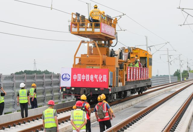 (260821) --CHENGDU, Aug. 21, 2026 (Xinhua) -- Constructors install overhead contact wires along the Jianzhou-Lezhi section of the Chengdu-Chongqing Central Line High-Speed Railway, southwest China's Sichuan Province, Aug. 21, 2026. The Chengdu-Chongqing Central Line High-Speed Railway will cover 292 kilometers with a designated speed of 350 km per hour upon completion. (Xinhua/Wang Xi)