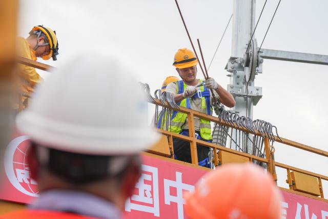 (260821) --CHENGDU, Aug. 21, 2026 (Xinhua) -- Constructors install overhead contact wires along the Jianzhou-Lezhi section of the Chengdu-Chongqing Central Line High-Speed Railway, southwest China's Sichuan Province, Aug. 21, 2026. The Chengdu-Chongqing Central Line High-Speed Railway will cover 292 kilometers with a designated speed of 350 km per hour upon completion. (Xinhua/Wang Xi)