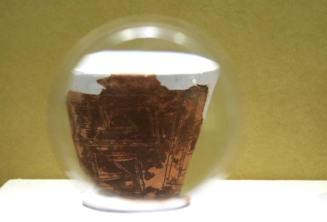 (260821) -- PINGTAN, Aug. 21, 2026 (Xinhua) -- A cultural relic is seen through a magnifier during the exhibition "Born by the Sea - Pingtan Prehistoric Culture" at the Keqiutou Site Museum in Pingtan, southeast China's Fujian Province, Aug. 20, 2026. Keqiutou Site Museum, a branch of the Chinese Archaeological Museum, is built around the Keqiutou ruins. It serves as an important platform for the study and presentation of Austronesian culture and for the display of the prehistoric culture of Pingtan. (Xinhua/Du Xiaoyi)