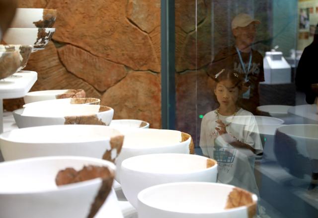 (260821) -- PINGTAN, Aug. 21, 2026 (Xinhua) -- A girl visits the exhibition "Born by the Sea - Pingtan Prehistoric Culture" at the Keqiutou Site Museum in Pingtan, southeast China's Fujian Province, Aug. 20, 2026. Keqiutou Site Museum, a branch of the Chinese Archaeological Museum, is built around the Keqiutou ruins. It serves as an important platform for the study and presentation of Austronesian culture and for the display of the prehistoric culture of Pingtan. (Xinhua/Du Xiaoyi)