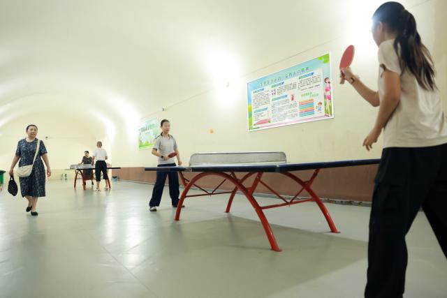 (260821) -- WUHAN, Aug. 21, 2026 (Xinhua) -- People play table tennis at a civil-defense facility repurposed as a public cooling space in Wuhan, central China's Hubei Province, July 14, 2026. (Photo by Zhao Jun/Xinhua)