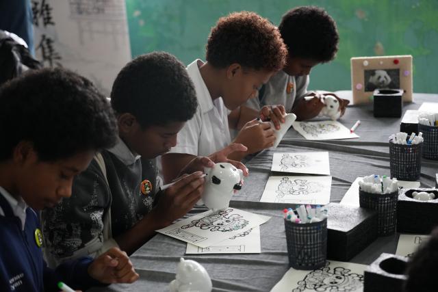 (260821) -- SUVA, Aug. 21, 2026 (Xinhua) -- Students of Rewa Secondary School paint on ceramic panda figurines during a session of the 9th "LANTING Culture Salon" organized by the Chinese Culture Center in Suva, Fiji, Aug. 21, 2026. (Xinhua/Bai Yongquan)