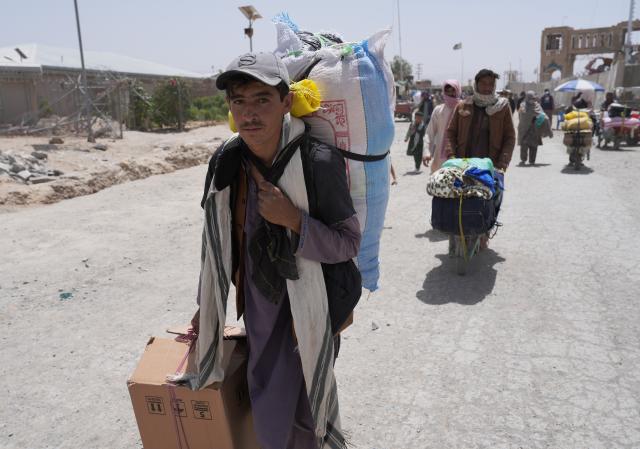(260821) -- KABUL, Aug. 21, 2026 (Xinhua) -- Afghan refugees are seen carrying their belongings at the Spin Boldak border crossing in Kandahar province, Afghanistan, Aug. 7, 2026. TO GO WITH "Feature: U.S.-Iran conflict, border tensions squeeze Afghan merchants, labor force" (Photo by Saifurahman Safi/Xinhua)