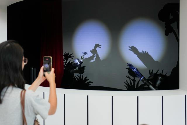 (260821) -- BEIJING, Aug. 21, 2026 (Xinhua) -- People watch a hand shadow dance of robot hands during the 2026 World Robot Conference in Beijing, capital of China, Aug. 20, 2026. The conference, which runs from Wednesday through Sunday, has drawn more than 300 exhibitors from 26 countries, with over 3,000 products on display, including more than 300 debuts. (Xinhua/Ju Huanzong)