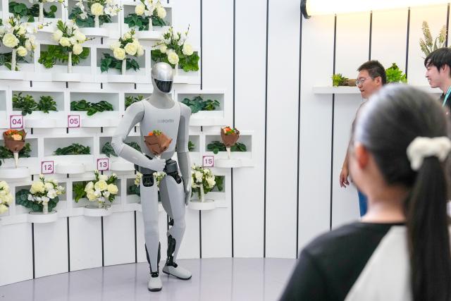 (260821) -- BEIJING, Aug. 21, 2026 (Xinhua) -- A humanoid robot delivers flowers to visitors during the 2026 World Robot Conference in Beijing, capital of China, Aug. 20, 2026. The conference, which runs from Wednesday through Sunday, has drawn more than 300 exhibitors from 26 countries, with over 3,000 products on display, including more than 300 debuts. (Xinhua/Ju Huanzong)