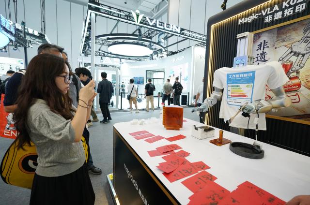 (260821) -- BEIJING, Aug. 21, 2026 (Xinhua) -- A robot makes a rubbing work during the 2026 World Robot Conference in Beijing, capital of China, Aug. 20, 2026. The conference, which runs from Wednesday through Sunday, has drawn more than 300 exhibitors from 26 countries, with over 3,000 products on display, including more than 300 debuts. (Xinhua/Zhang Chenlin)