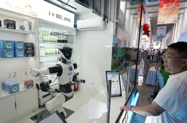 (260821) -- BEIJING, Aug. 21, 2026 (Xinhua) -- A humanoid robot works at a store during the 2026 World Robot Conference in Beijing, capital of China, Aug. 20, 2026. The conference, which runs from Wednesday through Sunday, has drawn more than 300 exhibitors from 26 countries, with over 3,000 products on display, including more than 300 debuts. (Xinhua/Zhang Chenlin)