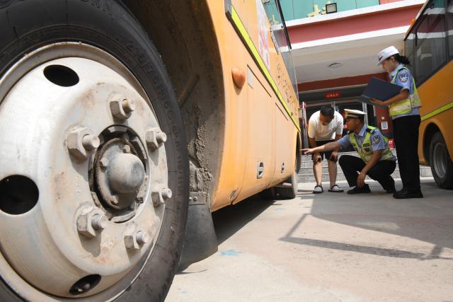 (260821) -- BEIJING, Aug. 21, 2026 (Xinhua) -- Traffic police officers inspect school buses at a primary school in Guangping County of Handan, north China's Hebei Province, on Aug. 21, 2026. Various departments across the country are getting ready for the upcoming new semester. (Photo by Cheng Xuehu/Xinhua)