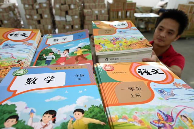 (260821) -- BEIJING, Aug. 21, 2026 (Xinhua) -- A staff member sorts out textbooks for the upcoming new semester at a warehouse in Neijiang, southwest China's Sichuan Province, on Aug. 20, 2026. Various departments across the country are getting ready for the upcoming new semester. (Photo by Lan Zitao/Xinhua)