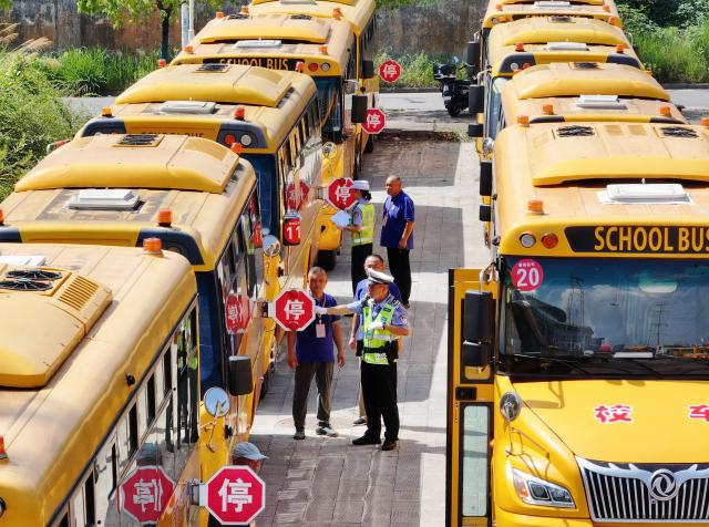 (260821) -- BEIJING, Aug. 21, 2026 (Xinhua) -- A drone photo taken on Aug. 21, 2026 shows traffic police officers inspecting school buses in Jiangxia District of Wuhan, central China's Hubei Province. Various departments across the country are getting ready for the upcoming new semester. (Photo by Zhao Jun/Xinhua)