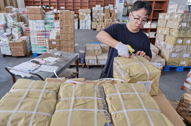 (260821) -- BEIJING, Aug. 21, 2026 (Xinhua) -- A staff member sorts out textbooks for the upcoming new semester in Haimen District of Nantong, east China's Jiangsu Province, on Aug. 20, 2026. Various departments across the country are getting ready for the upcoming new semester. (Photo by Xu Congjun/Xinhua)