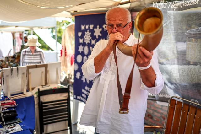 (260821) -- BUDAPEST, Aug. 21, 2026 (Xinhua) -- An artist plays a traditional horn during the Festival of Folk Arts at Buda Castle in Budapest, Hungary, Aug. 21, 2026. The annual festival showcases traditional Hungarian crafts and folk art as part of the celebration of Hungarian cultural heritage. (Photo by David Balogh/Xinhua)