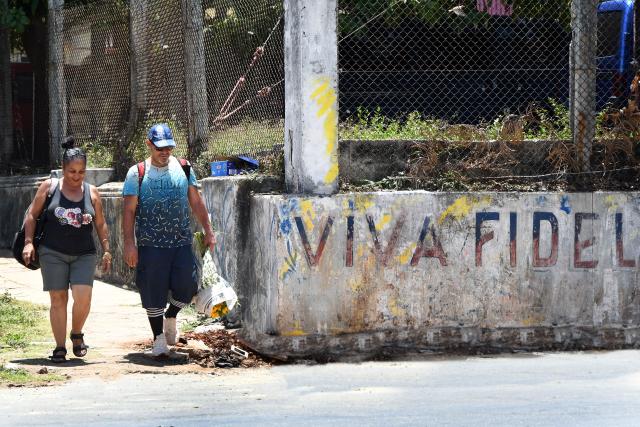 (260821) -- HAVANA, Aug. 21, 2026 (Xinhua) -- People walk past a slogan "Long live Fidel" in Havana, capital of Cuba, on Aug. 21, 2026. Cuban Foreign Minister Bruno Rodriguez on Thursday denounced Washington's increased sanctions against Cuban officials and entities, accusing the United States of deliberately seeking to strangle the island's economy and undermining the government's ability to provide basic services. (Photo by Joaquin Hernandez/Xinhua)