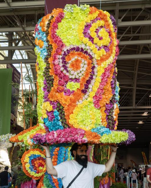 (260822) -- TORONTO, Aug. 22, 2026 (Xinhua) -- A man poses for photos with a floral installation on display at the 2026 Canadian National Exhibition (CNE) in Toronto, Canada, on Aug. 21, 2026. As one of the largest community events in Canada, the annual event runs from Aug. 21 to Sept. 7. (Photo by Zou Zheng/Xinhua)