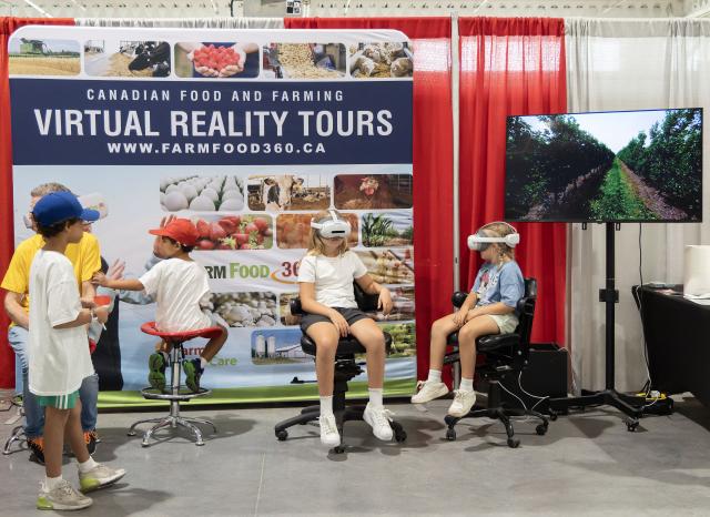 (260822) -- TORONTO, Aug. 22, 2026 (Xinhua) -- Children try on VR glasses to experience a virtual reality tour of Canadian food and farming at the 2026 Canadian National Exhibition (CNE) in Toronto, Canada, on Aug. 21, 2026. As one of the largest community events in Canada, the annual event runs from Aug. 21 to Sept. 7. (Photo by Zou Zheng/Xinhua)