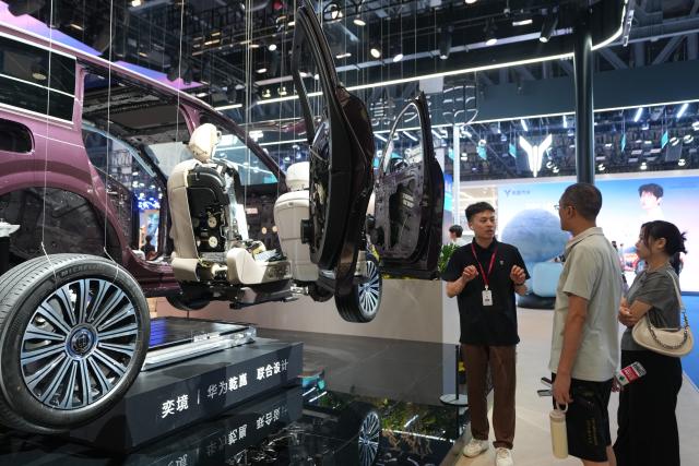 (260822) -- BEIJING, Aug. 22, 2026 (Xinhua) -- A staff member introduces a vehicle to visitors at the Chengdu Motor Show 2026 in Chengdu, southwest China's Sichuan Province, Aug. 21, 2026. The Chengdu Motor Show 2026 kicked off at Western China International Expo City in Chengdu on Friday. The show features around 1,600 vehicles from nearly 120 domestic and international brands and runs until Aug. 30. (Xinhua/Xu Bingjie)