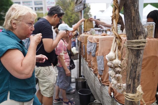 (260822) -- NEW YORK, Aug. 22, 2026 (Xinhua) -- People try herbal drinks at a farmers market in New York, the United States, on Aug. 21, 2026. (Xinhua/Zhang Fengguo)
