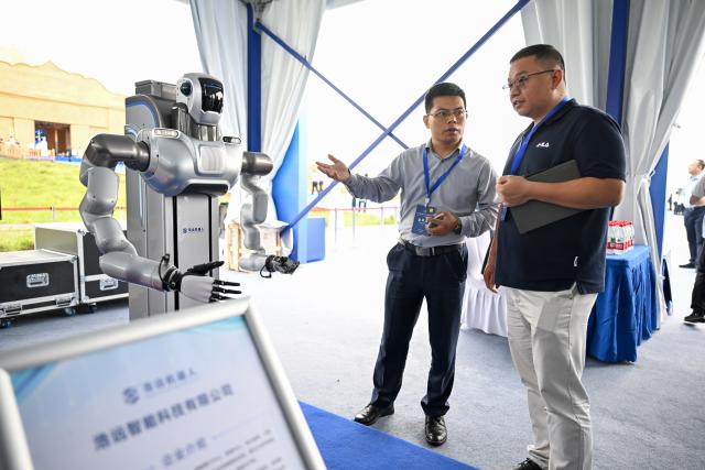 (260822) -- HOHHOT, Aug. 22, 2026 (Xinhua) -- Participants visit an exhibition during the 2026 Green Computing Power (Artificial Intelligence) Conference in Hohhot, north China's Inner Mongolia Autonomous Region, Aug. 22, 2026. The conference, which is held here on Saturday, reflects the latest progress of Inner Mongolia in green computing power supply, electricity-computing power coordination, and token economy. (Xinhua/Bei He)