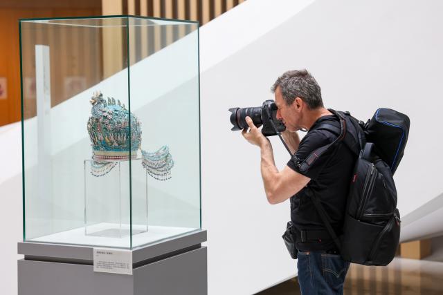 (260822) -- HANGZHOU, Aug. 22, 2026 (Xinhua) -- A member of a joint China-Russia media delegation takes photos of an exhibit at the China National Silk Museum in Hangzhou, east China's Zhejiang Province, Aug. 20, 2026. The delegation visited Hangzhou from Aug. 20 to 22, experiencing the charm of Chinese culture. (Xinhua/Jiang Han)