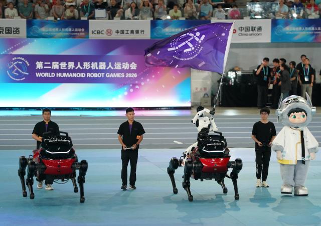 (260822) -- BEIJING, Aug. 22, 2026 (Xinhua) -- A humanoid robot waves the flag of the World Humanoid Robot Games during the opening ceremony of the 2nd World Humanoid Robot Games in Beijing, capital of China, Aug. 22, 2026. (Xinhua/Zhang Chenlin)