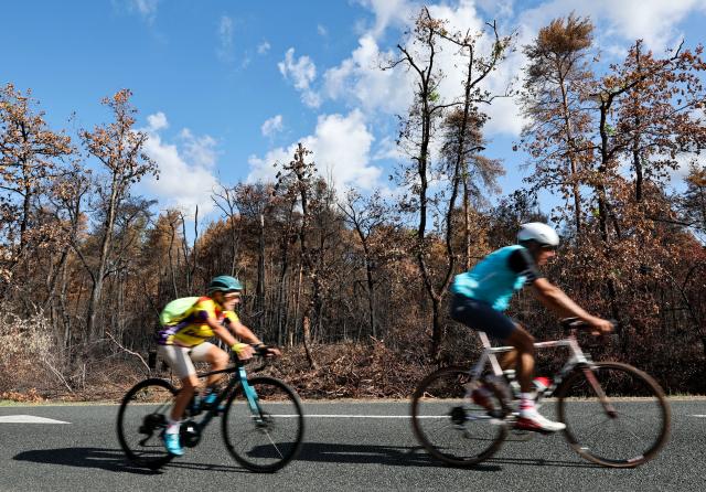 (260822) -- SEINE-ET-MARNE, Aug. 22, 2026 (Xinhua) -- People ride past an area burnt in a wildfire in the Fontainebleau Forest in Seine-et-Marne, France, Aug. 22, 2026. (Xinhua/Wu Huiwo)